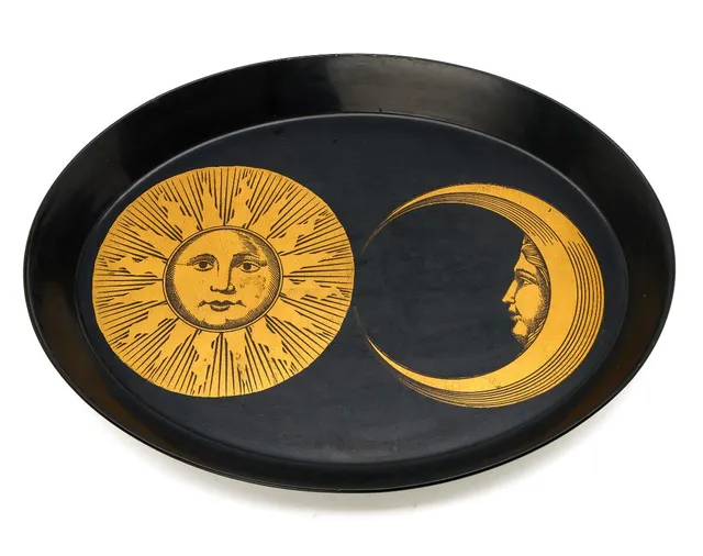 “Sole e Luna”. A black lacquered metal tray with golden sun and moon decor. Marked with paper label from Fornasetti, Italy. H. 4.5 cm. W. 34.5 cm. L. 45.5 cm.