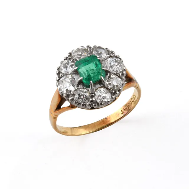 AN EMERALD AND DIAMOND CLUSTER RING.
