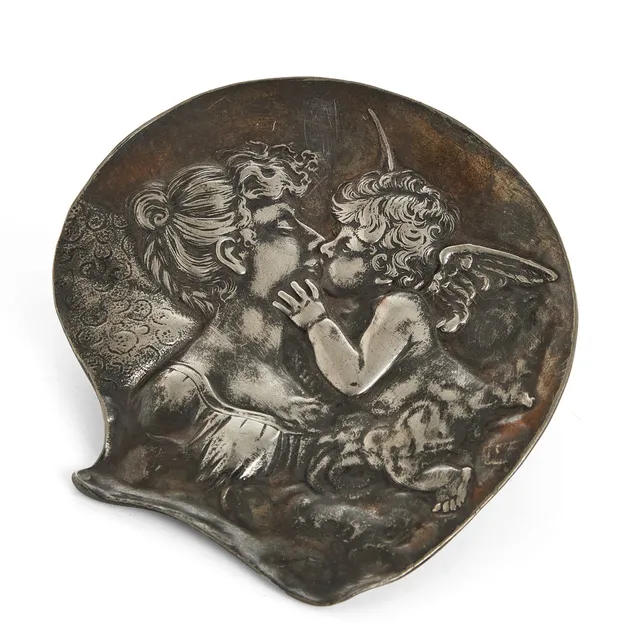 FAT. vitmetall. tidigt 1900-tal. Jugend. Reliefdekor med kvinna kyssandes amorin.