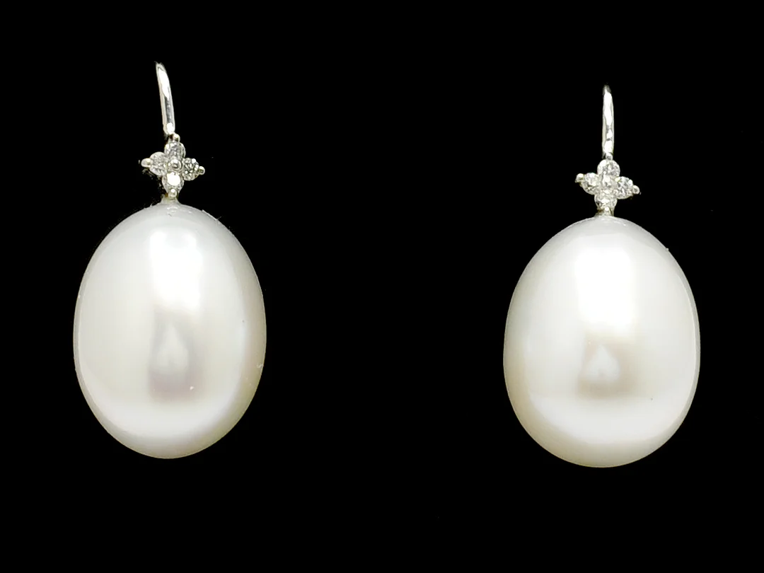 PÄRLÖRHÄNGEN, 18K vitguld, 2 odlade south sea pärlor ca 11,4 x 15 mm, ovala, 8 briljanter ca 0,04 ctv, krokar, vikt 6,7 g. — Smycken/Pärlörhängen — Kaplans
