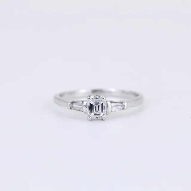 PLATINUM EMERALD CUT DIAMOND RING.