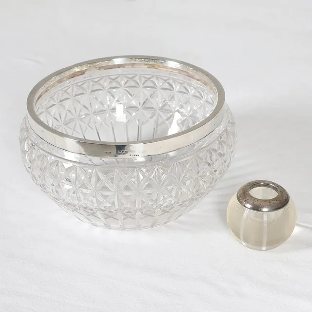 A VICTORIAN CUT GLASS & SILVER RIMMED BOWL, AND AN EDWARDIAN GLASS & SILVER COLLARED GLOBULAR MATCH STRIKE.