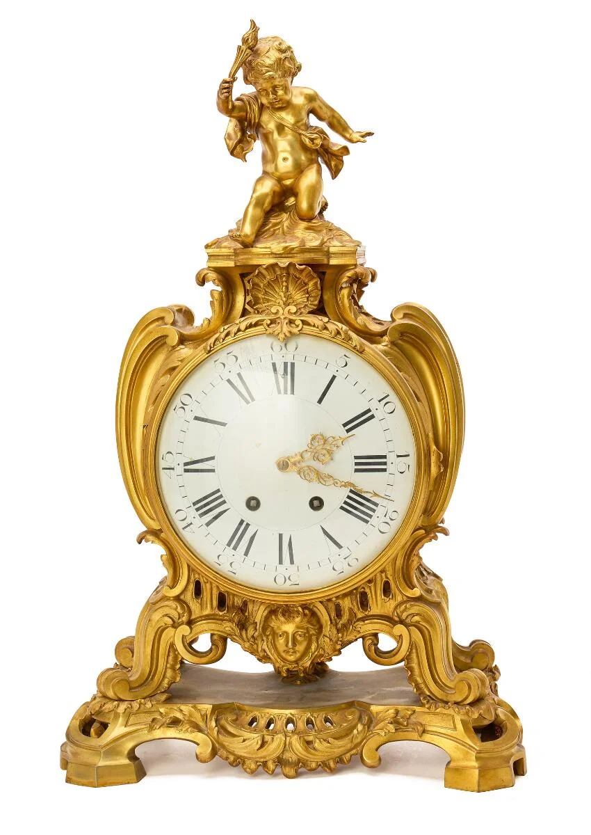 A French Napoleon III mantel clock of gilded bronze, white enamel dial, clock case with seat putto and ornaments. Paris, late 19th century. H. 70. W. 43. D. 22. — Clocks & watches/Mantel & Wall Clocks — Bruun Rasmussen