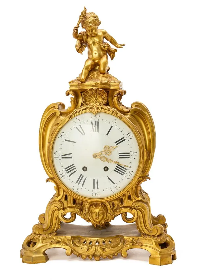 A French Napoleon III mantel clock of gilded bronze, white enamel dial, clock case with seat putto and ornaments. Paris, late 19th century. H. 70. W. 43. D. 22.