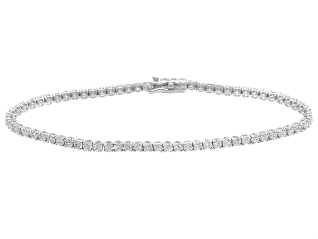 TENNISARMBAND, 18K vitguld, 70 briljantslipade diamanter ca 2,50 ctv, ca TW-Cr(F-J)/VS-SI, längd 17 cm, vikt 6,6 g, några diamanter har nagg. — Smycken/Armband — Kaplans