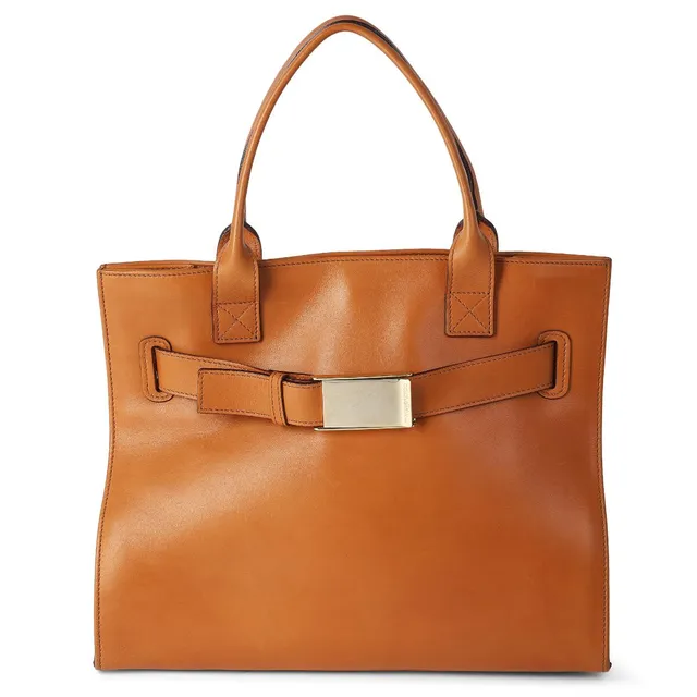 A bag of light brown leather with gold-toned hardware, two handles, a compartment with magnetic closure, an internal zip pocket and brown fabric lining. H. 28 x W. 31 x D. 13 cm.