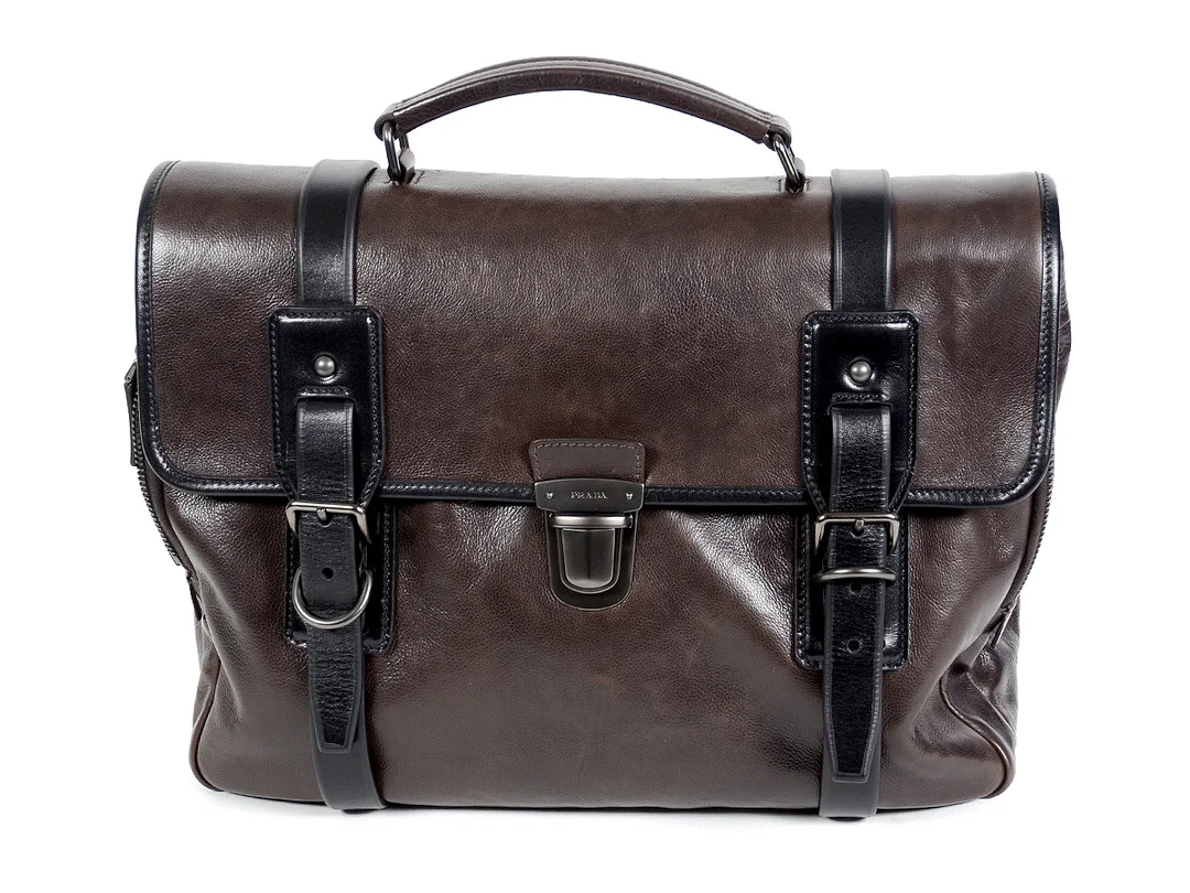 PORTFÖLJ, PRADA, mörkbrunt, svart kalvskinn, 36x28x16 cm, detaljer i grå matt metall, dustbag. — Accessoarer/Väskor — Kaplans