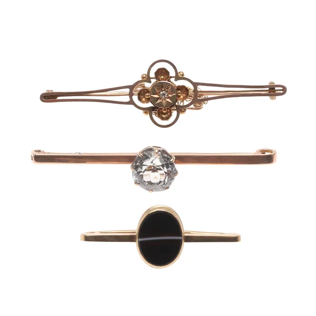 THREE EARLY 20TH CENTURY GOLD BAR BROOCHES.