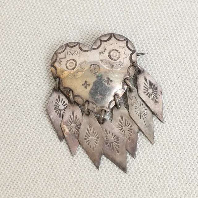 DRÄKTBROSCH, silver, hjärtformad med rombformade hängen.