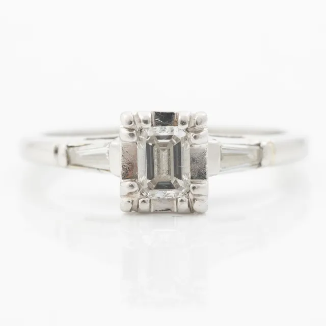 Ring platina med smaragdslipad diamant och modifierade baguetteslipade diamanter.
