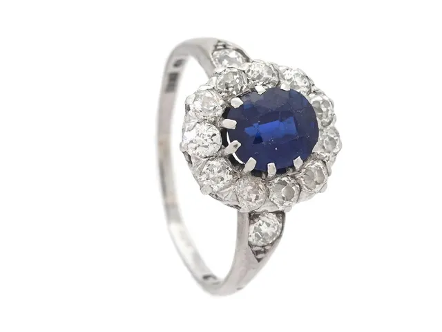 CARMOSÉRING, 18K vitguld, blå safir, 13 gammalslipade diamanter ca 0,65 ctv, ca TCr/VS, Hovjuvelerare Carlman Stockholm 1929, stl 17 mm, vikt 3,5 g, nedslitna klor, safir med slitna fasettkanter och nagg, skev ringskena.