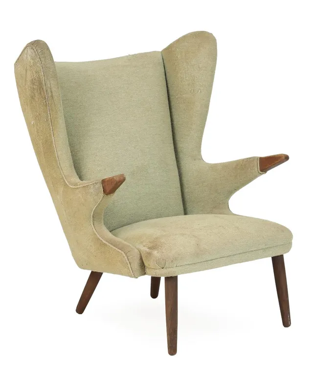 Svend Skipper: Wingback chair with teak legs and “nails”, upholstered with greenish wool. Manufactured by Skipper's Møbler.