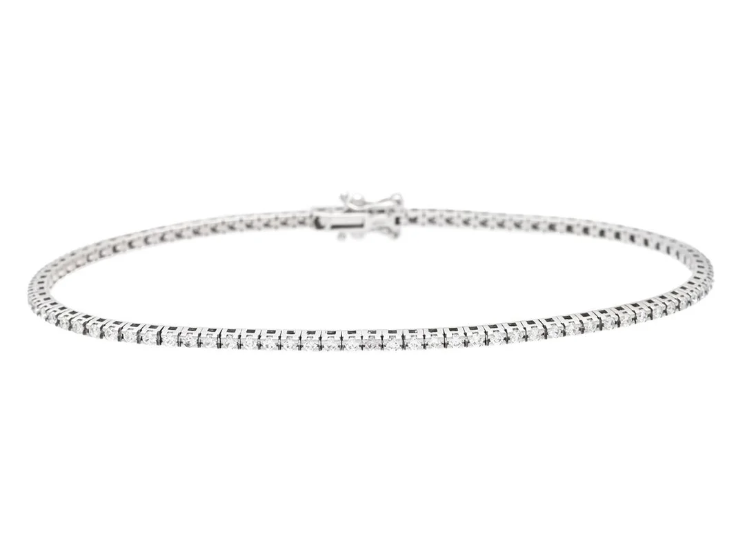 TENNISARMBAND, 18K vitguld, 91 briljantslipade diamanter ca 0,96 ctv, ca TW-Cr/VS-SI, längd 18 cm, vikt 6,5 g, en diamant med skada. — Smycken/Tennisarmband — Kaplans