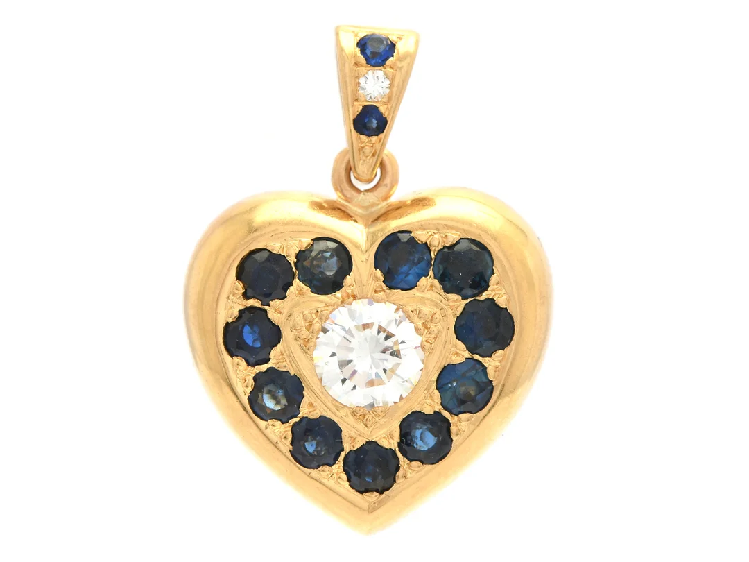HÄNGE, 18K guld, hjärta, briljantslipad diamant ca 0,65 ct, ca TW(F)/VS1, briljantslipad diamant ca 0,02 ct, ca W(H)/VS, 13 blå safirer ca 1,50 ctv, stl 27 x 19 mm, vikt 15,6 g, några safirer med slitage på fasettkanter. — Smycken/Hänge — Kaplans
