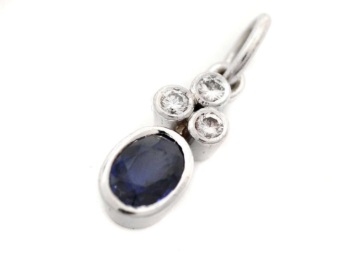 HÄNGE, 18K vitguld, ovalt fasettslipad safir, mindre skada i kronan, 3 briljantslipade diamanter ca 0,06 ctv, vikt 3,9 g. — Smycken/Hänge — Kaplans