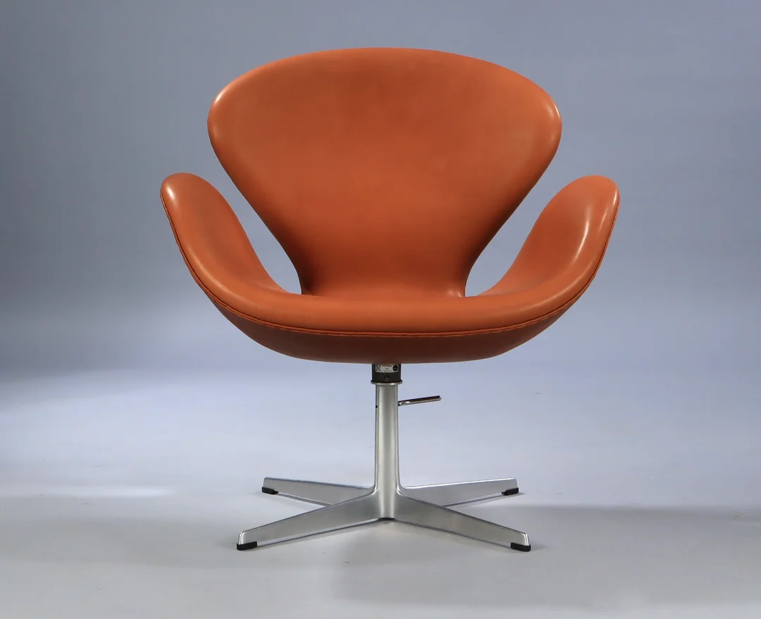 Arne Jacobsen. Lounge chair 'The Swan' with manual height adjustment, upholstered in cognac-coloured aniline leather. — Furniture/Lounge chairs — Lauritz