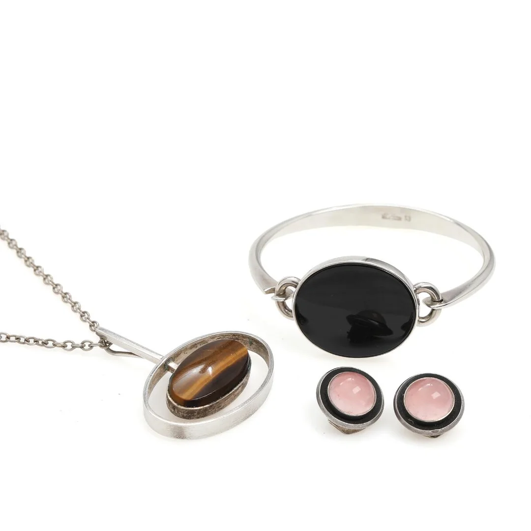 Pendant, bangle and pair of ear clips set with cabochon tiger's eye, onyx and rose quartz, mounted in sterling silver. Silver chain included. Pendant L. 4.5 cm. Ear clips diam. 1.6 cm. (4) — Jewellery — Bruun Rasmussen