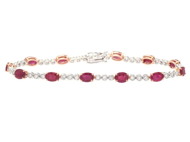 ARMBAND, 18K guld/vitguld, 39 briljantslipade diamanter ca 0,72 ct, ca G-H/VS, 12 ovalslipade rubiner ca 6,8 ctv, längd 18 cm, vikt 8,1 g.