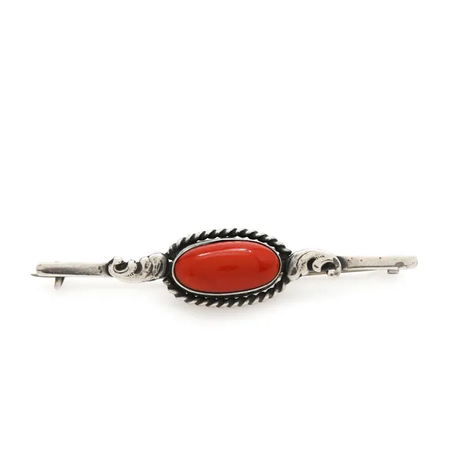 A coral brooch set with cabochon coral, mounted in silver. L. 7 cm.