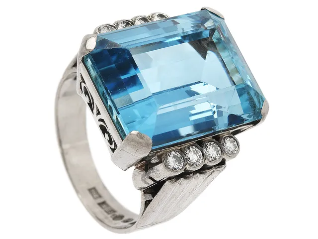 RING, 18K vitguld, smaragdslipad akvamarin ca 17,00 ct, 8 briljantslipad diamant ca 0,30 ctv, ca W(H)/VS, Guldsmed Georg Törnblom, Stockholm 1959, stl 17 mm, vikt 12,7 g, akvamarinen med slitna fasettkanter och små nagg.