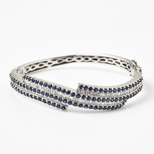 ARMRING, 18 k vitguld, dekor med 50 fasettslipade safirer samt flertalet baguette- och trapetsslipade diamanter, engelska stämplar, Sheffield 2017.