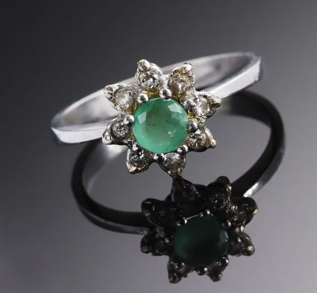 Rosette emerald and diamond ring of 18 kt. rhodium-plated white gold, total approx. 0.16 ct.