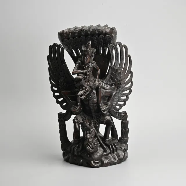 AN INDONESIAN BALINESE WOODEN SCULPTURE OF VISHNU RIDING GARUDA, LATE 20TH CENTURY.