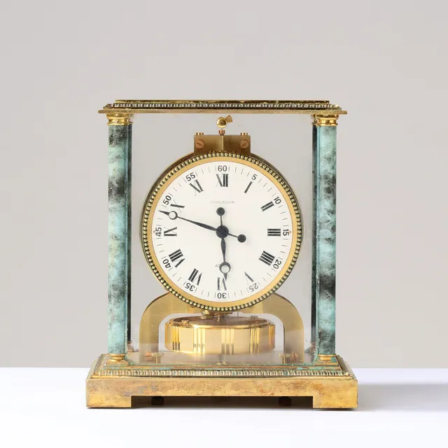 JAEGER LE COULTRE. Bordur model 'Atmos Vendome' af forgyldt messing med plexiglas og marmorerede hjørnesøjler, 1970'erne.