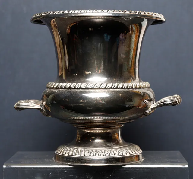 Medici-like ice bucket in silvery metal.