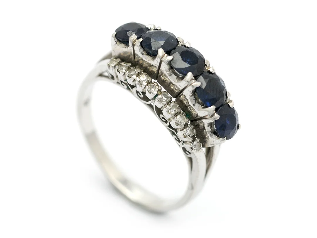 RING, 18K vitguld, 5 blå safirer, 3 mindre skadade, 21 åttkantslipade diamanter ca 0,15 ctv, stl 17,5 mm, vikt 4,4 g. — Smycken/Ring — Kaplans