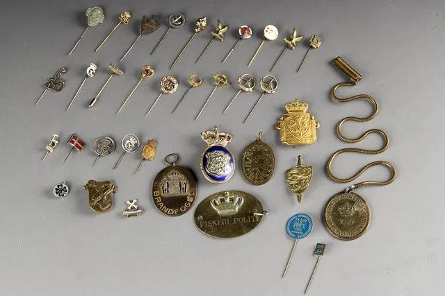 Samling pins og politiskilte, bla. guld