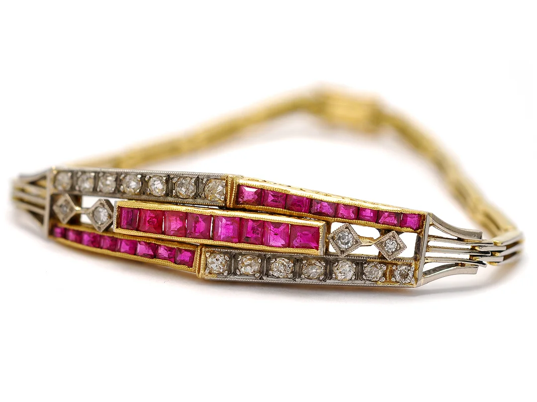ARMBAND, 18K guld/platina, carréslipade rubiner, 18 diamanter ca 0,70 ctv, ca CR/SI, inneslutningar når ytan, längd 16 cm, vikt 13 g. — Smycken/Armband — Kaplans
