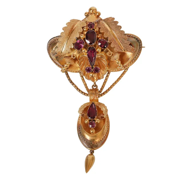 A VICTORIAN YELLOW METAL AND ALMANDINE GARNET BROOCH.