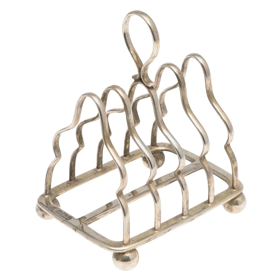 AN EDWARDIAN SILVER FOUR PLACE SILVER TOAST RACK. — Silver — Lawrences Auctioneers