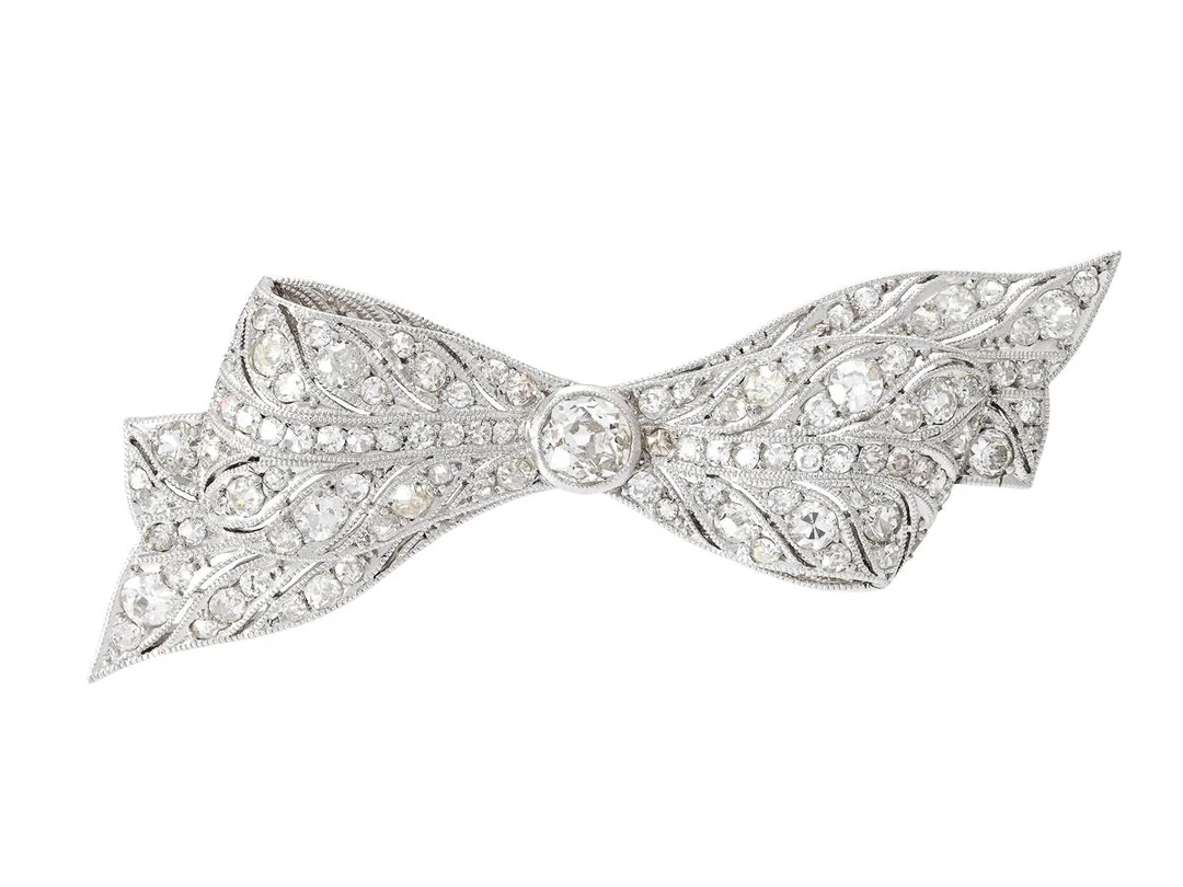 BROSCH, rosett, platina, gammal- och åttkantslipade diamanter ca 1,70 ctv, Art Deco, 1930-tal, mått 50x20 mm, vikt 9,2 g, nål i 18K vitguld, några diamanter har nagg och skador, etui. — Smycken/Brosch — Kaplans