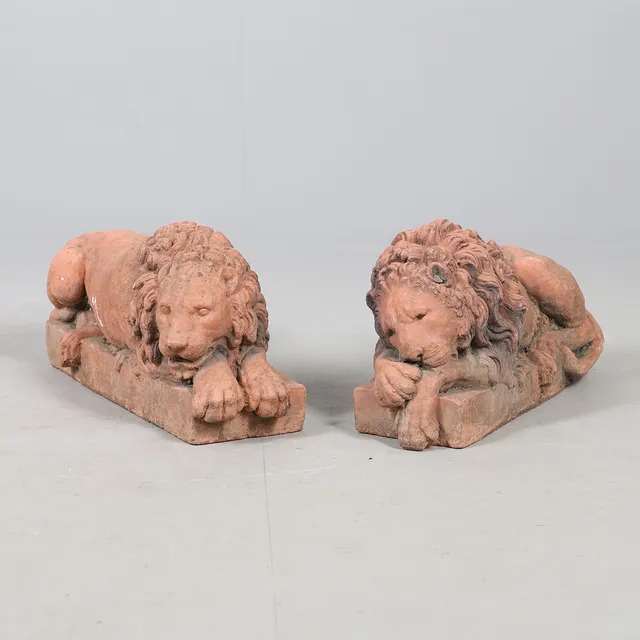 A PAIR OF TERRACOTTA RECUMBANT LIONS.