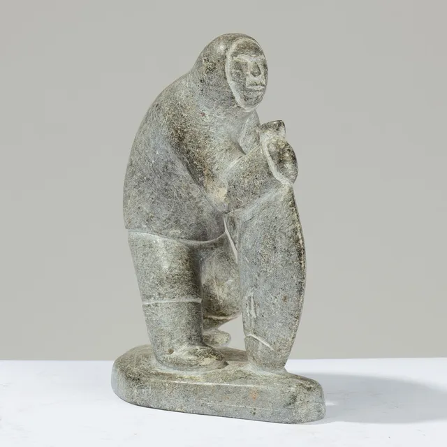 SIMON KRISTOFFERSEN (1933–1990). Unik skulptur udskåret af fedtsten forestillende grønlandsk jæger holdende stor fisk, signeret og dateret '89', Nuuk, Grønland.