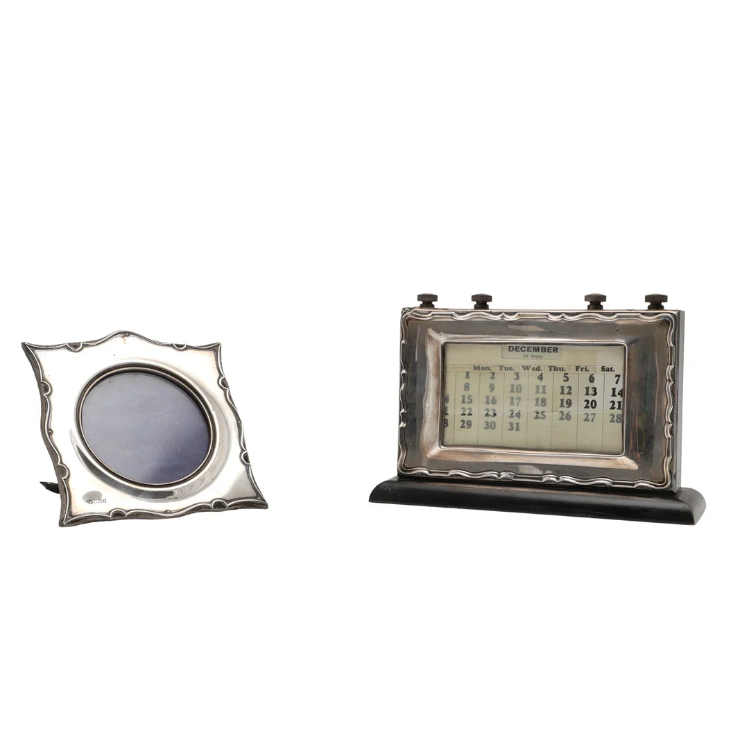 A GEORGE V SILVER FRAMED PERPETUAL CALENDAR AND AN EDWARDIAN SILVER PHOTOGRAPH FRAME. — Silver — Lawrences Auctioneers