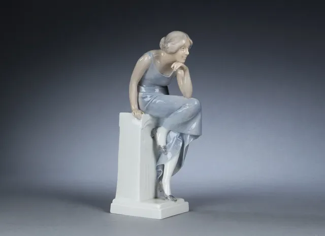 Axel Locher for Royal Copenhagen. Ung kvinde siddende på en stensokkel. Sjælden figur, nr. 568, 2.sort