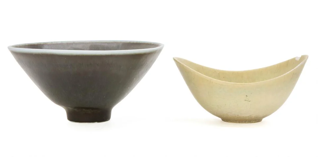 Two stoneware bowls. The larger bowl modelled in a slightly three-sided form and decorated with dark grey glaze. The smaller bowl modelled in a boat-shaped form and decorated with yellow glaze. Signed CHS and GN. Made and marked by Rörstrand. H. resp. 9 and 7.5 cm. Diam./L. resp. 18.3 and 16 cm. (2) — Modern Decorative Art — Bruun Rasmussen
