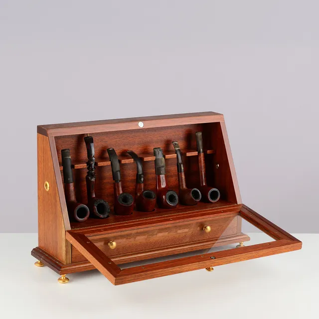 En samling assorterede piber og pibeskab af mahogni og glas med klaplåge og skuffe, greb af messing, 1900-tallet (1+14+2).