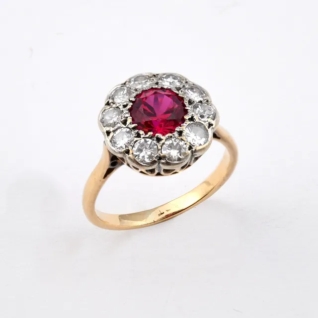 A SYNTHETIC RUBY AND DIAMOND CLUSTER RING.