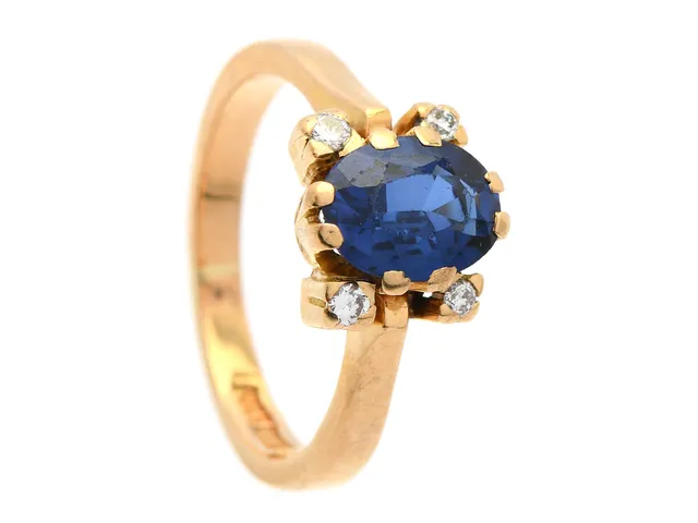 RING, 18K guld, ovalslipad blå safir ca 1,80 ct, 4 briljanter ca 0,08 ctv, ca W/VS, stl 16,75 mm, vikt 4,7 g, safir med mindre nagg och slitna fasettkanter.