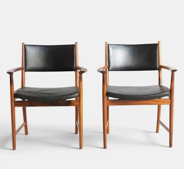 KAI LYNGFELDT LARSEN (F. 1919, D. 1976). Et par armstole med stel af palisander, sæde og ryg med sort skind. Udført og mærket hos Søren Willadsen, Vejen. Danmark, 1960'erne (2).
