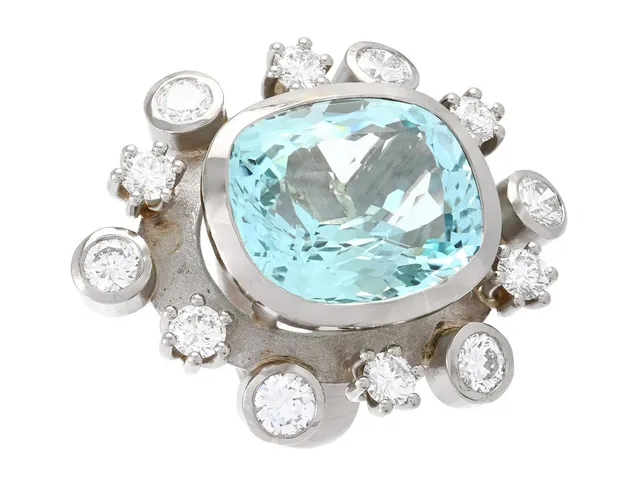 RING, 18K vitguld, kuddslipad akvamarin ca 25,00 ct, 12 briljantslipade diamanter ca 4,50 ctv, ca R-TW/VVS-VS, stl 19,25 mm, vikt 30,3 g, akvamarinen har nagg.