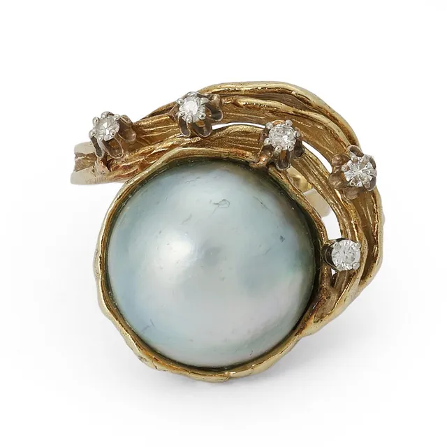 A pearl and diamond ring set with a mabé pearl and brilliant-cut diamonds, mounted in 14k gold. Weight app. 12 g. W. 20 mm. Size 53.5.