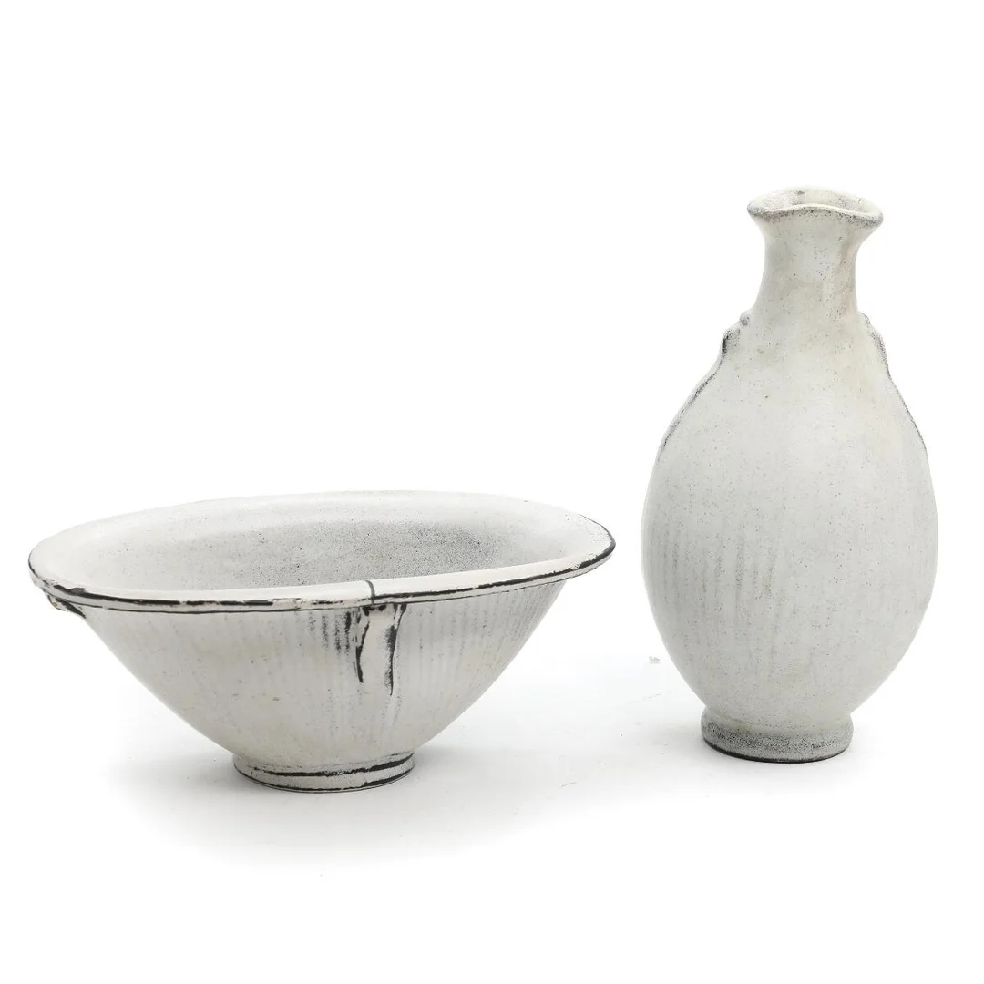 Earthenware bowl and vase, modelled with fluted pattern and small “handles”. Decorated with black/white double glaze. Signed HAK. Manufactured by Kähler. Bowl H. 9. L. 22.5. Vase H. 22 cm. (2) — Modern Decorative Art — Bruun Rasmussen