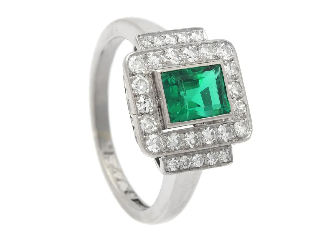RING, platina, smaragd ca 0,90 ct, 28 åttkantslipade diamanter ca 0,35 ctv, ca TW-TCr/VS-SI, Erik Thomassons Guld-& Juvelfirma, Stockholm 1953, stl 15,5 mm, vikt 6,2 g, storleksändrad, två diamanter har nagg vid rondisten, smaragden har nagg i ena hörnet och i anslutning till stor inneslutning som når ytan. — Smycken/Ring — Kaplans