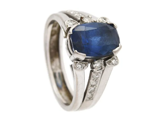 RING, 18K vitguld, blå safir 3,32 ct enligt gravyr, 14 briljant- och åttkantslipade diamanter 0,19 ctv enligt gravyr, ca TW-TCr/VS-SI, Rolf Jacobsson & Gösta Rosin, stl 15 mm, vikt 6,6 g, storleksändrad, skev ringskena, nagg.