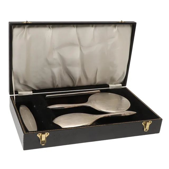 A CASED SILVER BACK DRESSING TABLE SET AND A CASED HAIR BRUSH.